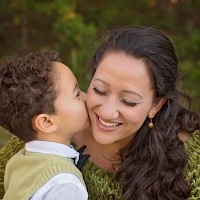 A little boy giving his laughing mom a kiss on the cheek