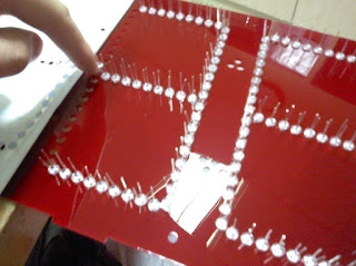 LEDs being pushed into the sheet of acrylic
