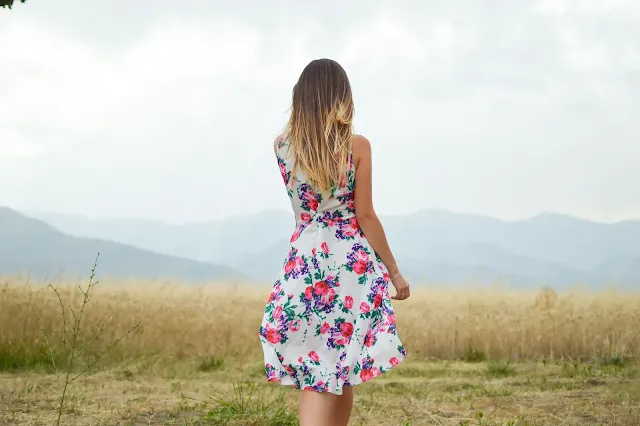 A girl wearing a floral dress as a summer outfit