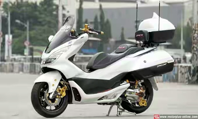 Foto Modifikasi Honda PCX modifikasi Touring elegan dengan warna putih polos PCX dipadukan dengan warna hitam agar makin terlihat gahar menambahkan beberapa bagian body seperti spion sidebox dek pelek original PCX diganti pakai kepunyaan skuter gambot yang berdiameter 17 inci ban