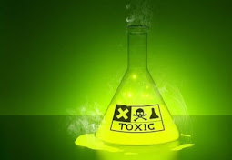 The image shows a chemical flask filled with a hazardous substance. The flask is in a laboratory where scientific research is conducted. The flask has a label with the words "TOXIC", which warns of the danger of the substance inside.