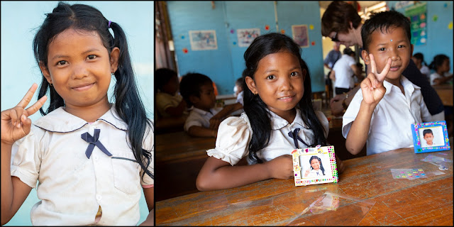 Young Cambodian girl poses for her portrait. Then showing her decorated framed photo.