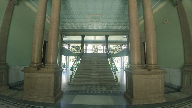 A majestic staircase inside Palacio Nacional El Salvador, a testament to its architectural grandeur.