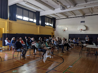 Group of people sitting in an auditorium watching a presentation