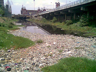 You rarely see this view. Chennai Central is in the background with a mound of trash in the Buckingham Canal, as seen from pedestrian walkway to Park Town MRTS Station