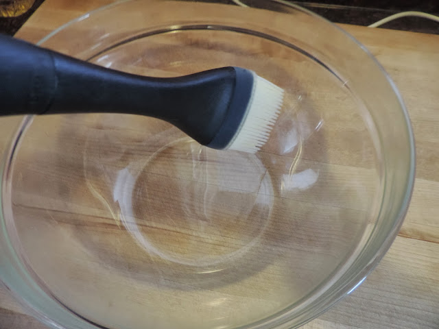 A mixing bowl being brushed with oil.