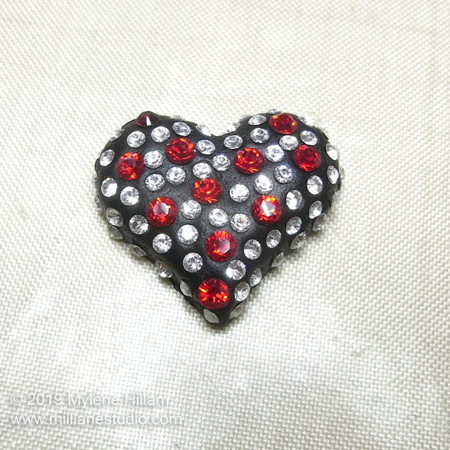 Black resin clay heart studded with Light Siam and clear crystals.