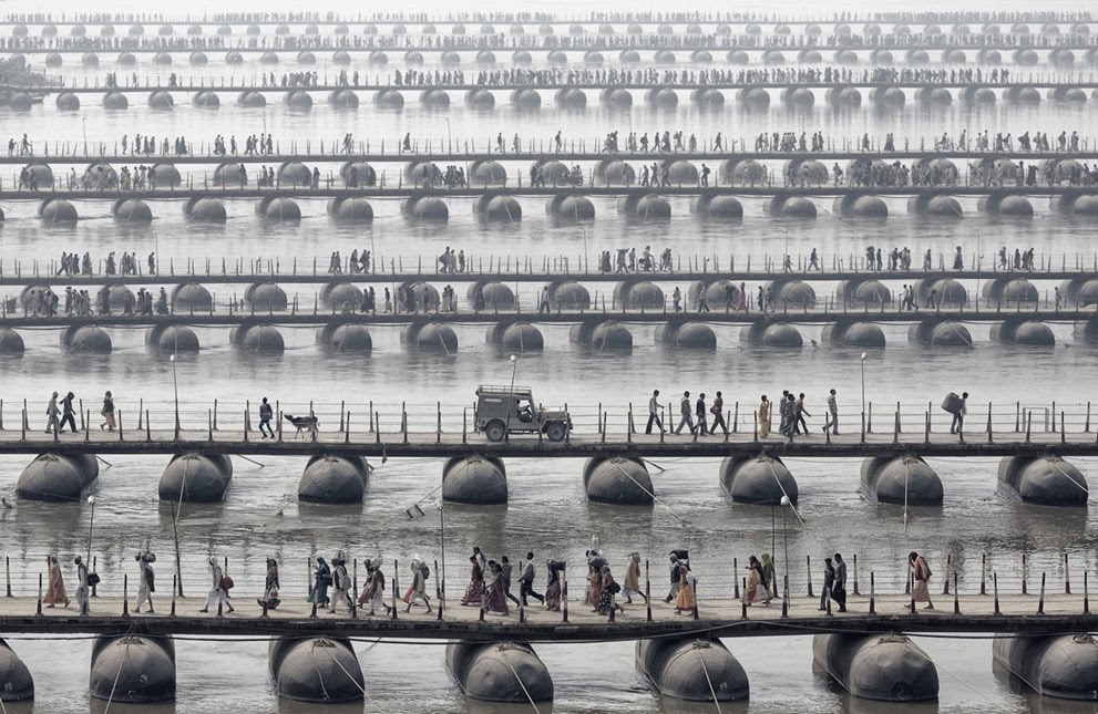 pilgrims and devotees cross pontoon bridges