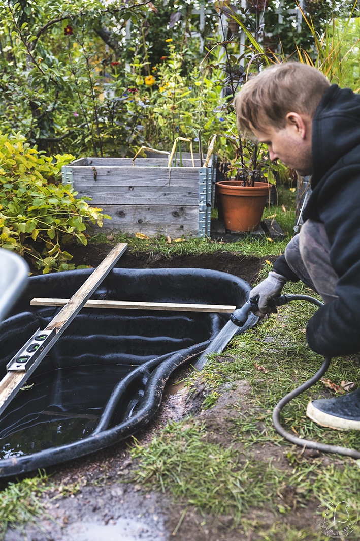 Vesiaiheen teko puutarhaan – tiivistetään hiekka vedellä.