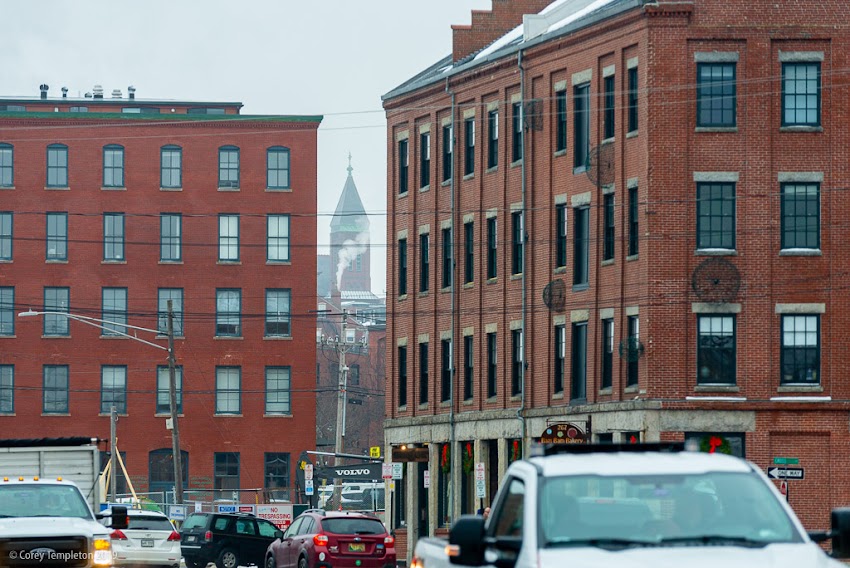 Portland, Maine USA December 2019 photo by Corey Templeton. A temporary glimpse of St. Dominic's Church beyond the hustle and bustle of Commercial Street. 