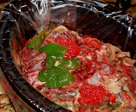 this is a slow cooker with venison, peppers and mushrooms in it
