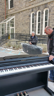 Rudy Lucente in background watching Grafton unload Kawai piano