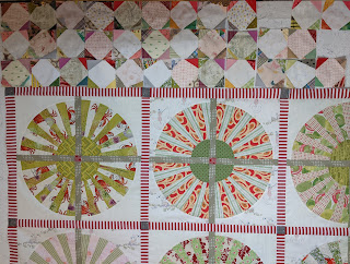 This version of the snowball borders has corners that closely match the colors and values of the Wheel blocks in the center of the quilt