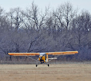 Ultralight Aircraft from Belite touching down (yellow ultralight aircraft)