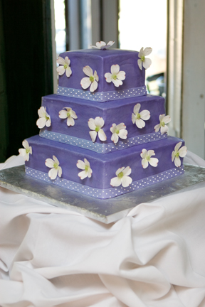 Square three tier purple wedding cake with cute white flowers