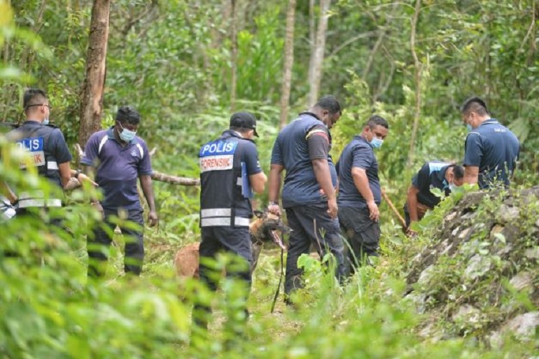 Anggota polis dari Unit Forensik terus melakukan pencarian di dalam kawasan hutan di Taman Bukit Zamrud, Seremban, hari ini. - Foto Utusan