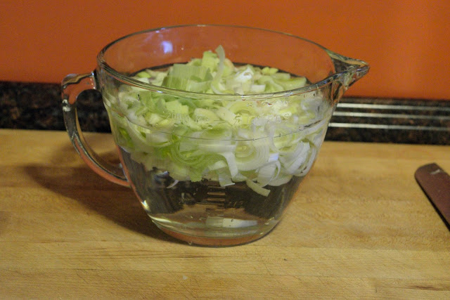 The sliced leeks in a mixing bowl of water.