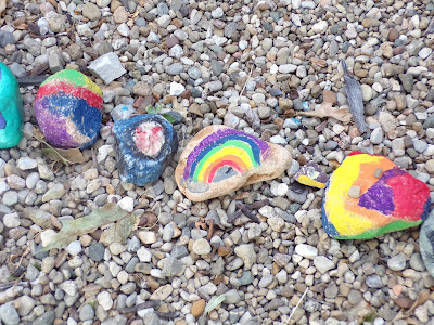 a collection of rainbow painted rocks.