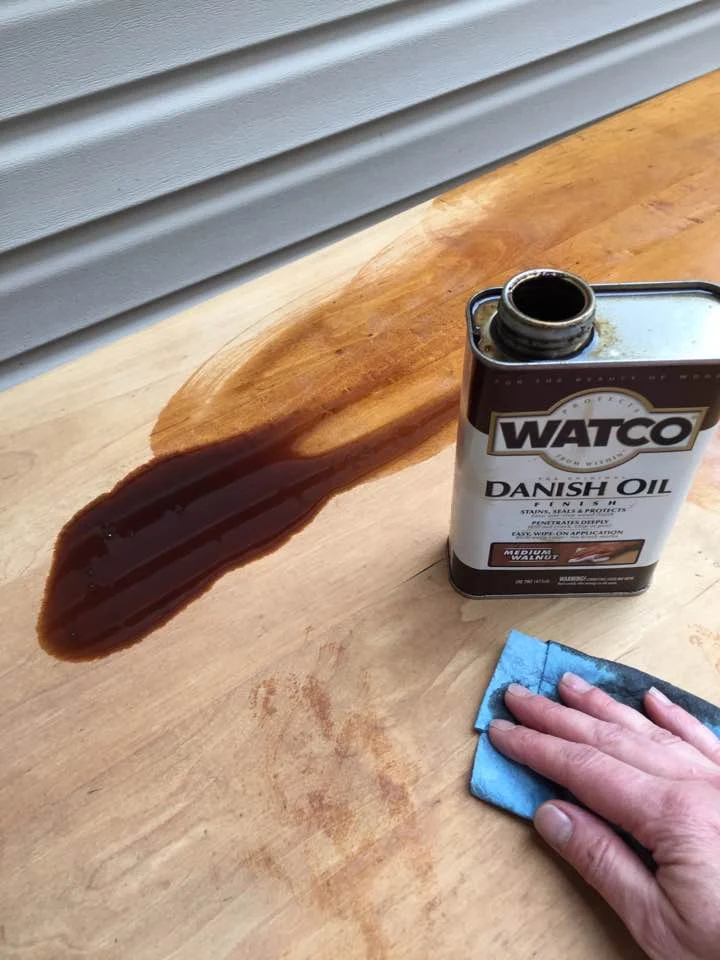 Applying Danish Oil to wood table top.