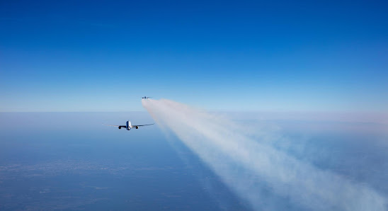 un avion diffuse des trainées l'autre qui vole à la même altitude non