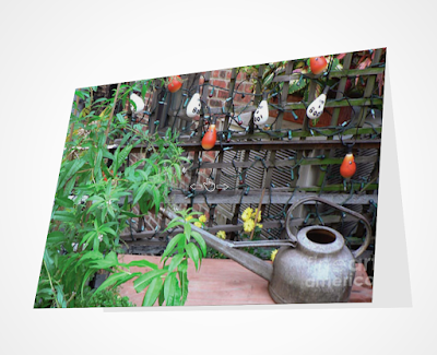 This screen-shot features a Halloween card which has an image imprinted on it. The picture was taken in my garden when decorated for Halloween. It shows Halloween-themed outdoor lights hanging on a wooden trellis. It can be purchased via Fine Art America @ https://fineartamerica.com/featured/halloween-in-the-garden-patricia-youngquist.html?product=greeting-card