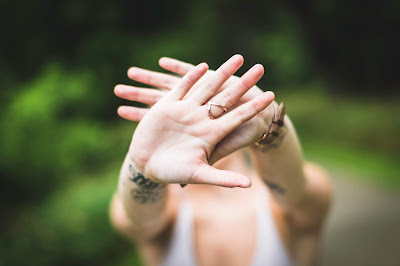 Mujer escondiéndose detrás de sus manos