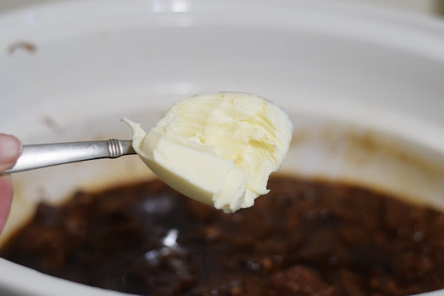 Vegan butter being added to the crockpot.