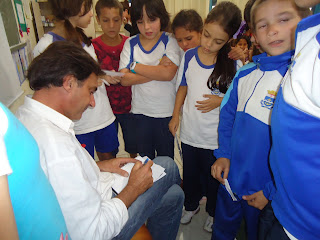 Nosso artista com muita honra dando seu autografo para os alunos.