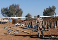 A bomb disposal Soldier guards improvised explosive devices the company has recovered in the recent months from the Ninewa province, Dec. 5. The display was set out for an upcoming visit from their Iraqi army division commander.