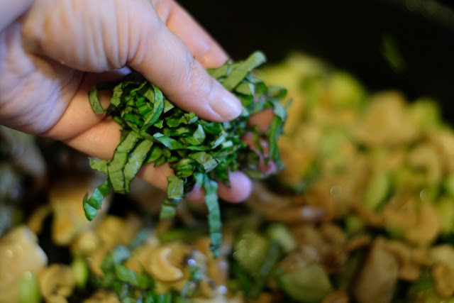 Basil being added to the stir fry.  