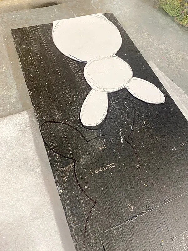 bunny shape traced on black painted wood