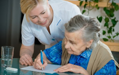 old blind woman being helped to sign a document