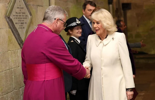 Queen Camilla wore a white cashmere coat and animal print silk dress. Pearl drop earrings and gold brooch
