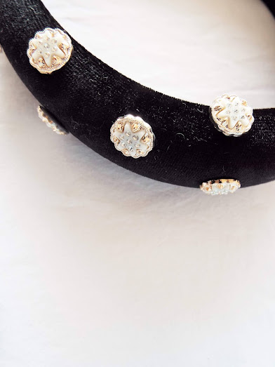 Close up picture of the black velvet pealed headband, showing the star-shaped pearls and gold detailing.