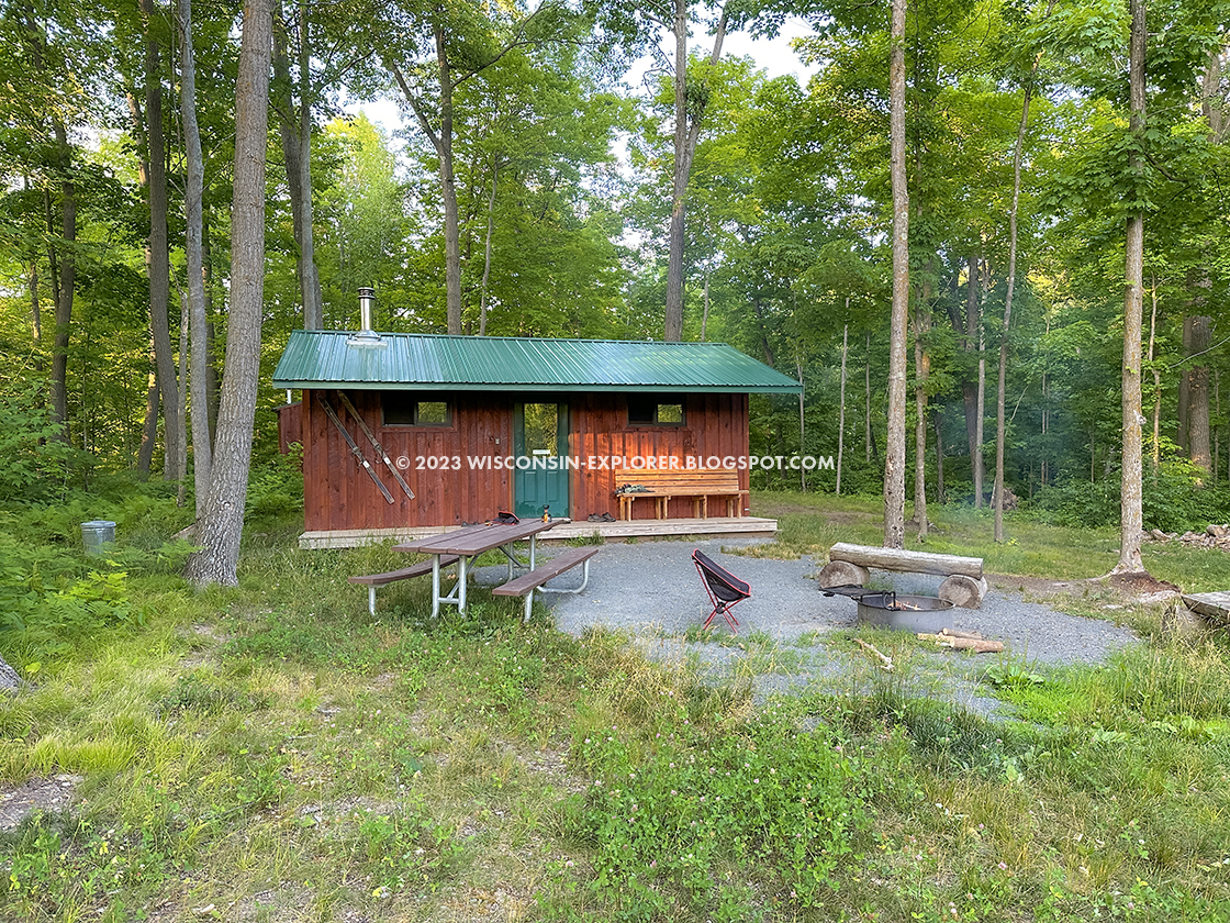 small cabin with picnic table and fire ring