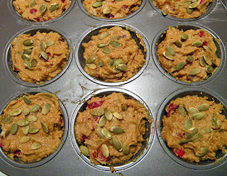 Muffin Tins Filled with Batter and Topped with Pumpkin Seeds