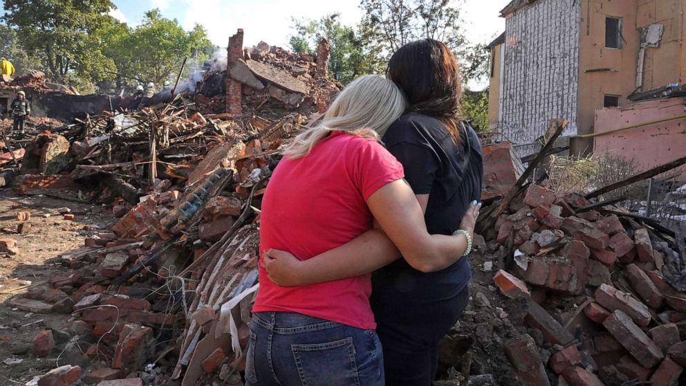 Ukrainian ladies embrace before a structure obliterated during a rocket strike in Kharkiv, Ukraine