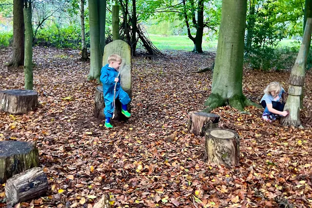 Looking at a fairy door and playing with wooden stumps at Markshall Estate