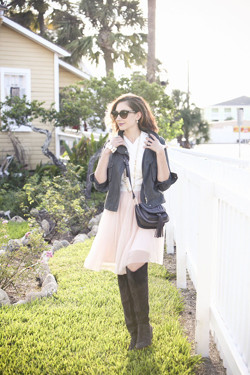 Amy West in over the knee boots, military jacket, western cross body bag, and classic tulle dress from Anthropologie