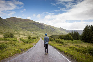 Homme regardant le sentier qui se perd à l'horizon