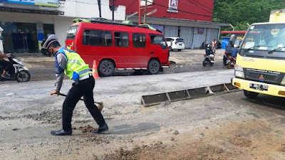 Berikan Kenyamanan Pengguna Jalan, Polantas Ini Rela Urug Jalan Berlubang