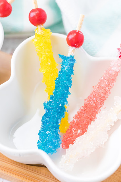 Rock Candy on a stick in a white bowl.