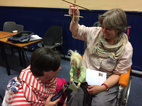 photo of Persephone Sextou and puppet Johnny Dwyer having a private moment.  Corina Duyn is holding the puppet