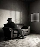 Silueta de hombre viendo la televisión recostado en un viejo sofá