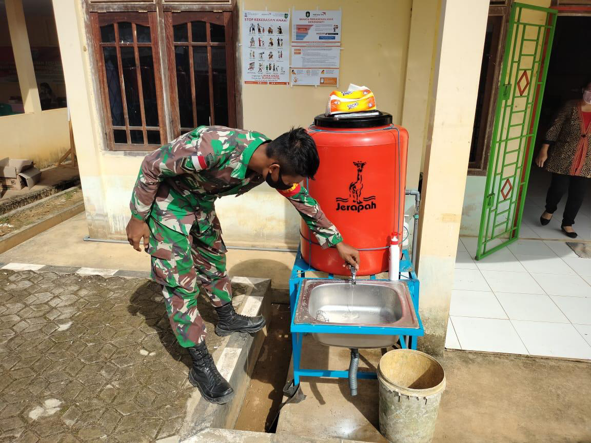 Anggota satgas TMMD pastikan kran air cuci tangan berjalan dengan baik