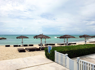 Beach with thatch umbrellas and lounge chairs