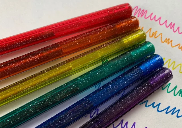 A close up of 6 glitter gel pens and their ink