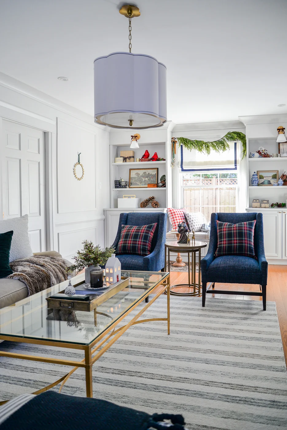 living room christmas decor with plaid pillows, velvet bows, and faux garlands