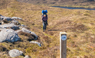 Walking with heavy pack  Hebridean Way walking marker 