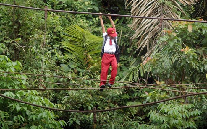 A
                                  boy climbs a wire across a river to
                                  get to school in Pintu Gabang,
                                  Indonesia. These children have to
                                  tightrope walk 30 feet above a flowing
                                  river to get to their class on time
                                  and then walk a further seven miles
                                  through the forest to their school in
                                  the town of Padang...Picture: Panjalu
                                  Images / Barcroft Media 